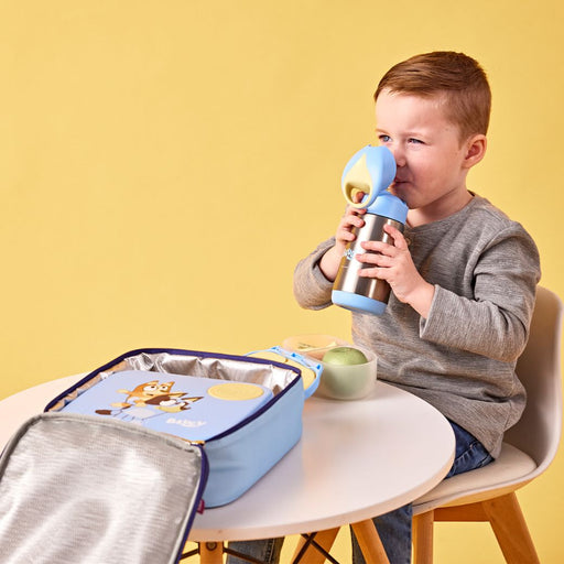 child sitting at a table drinking a b.box bluey drink bottle
