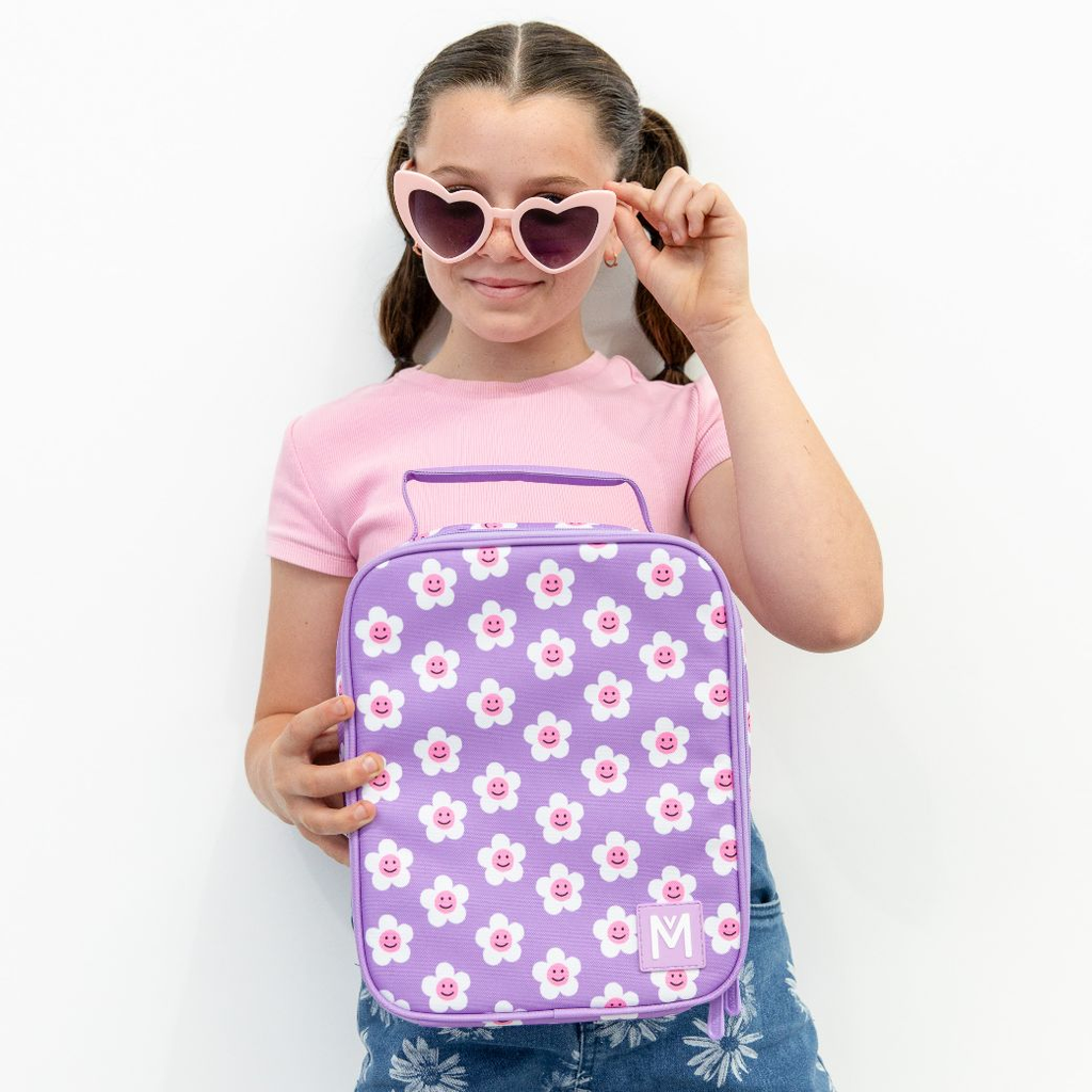 purple white and pink daisy lunch bag being held by a school aged child